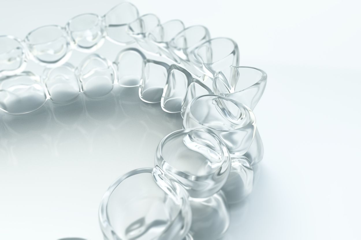 Modell einer transparenten Invisalign Korrekturschiene für Kinder in der kieferorthopädischen Praxis KFO am Grindel